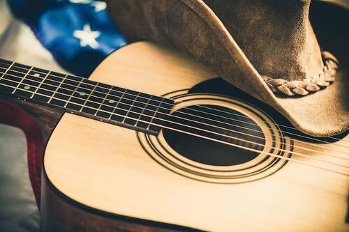 bilde av en gitar, ein cowboyhatt og delar av eit amerikansk flagg